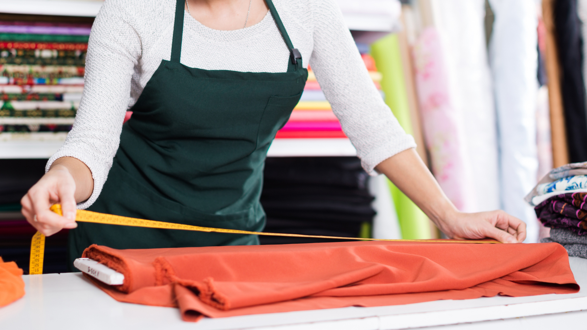 Entrepreneur measuring fabric in a workshop, representing the work of a textile startup developing innovative materials.