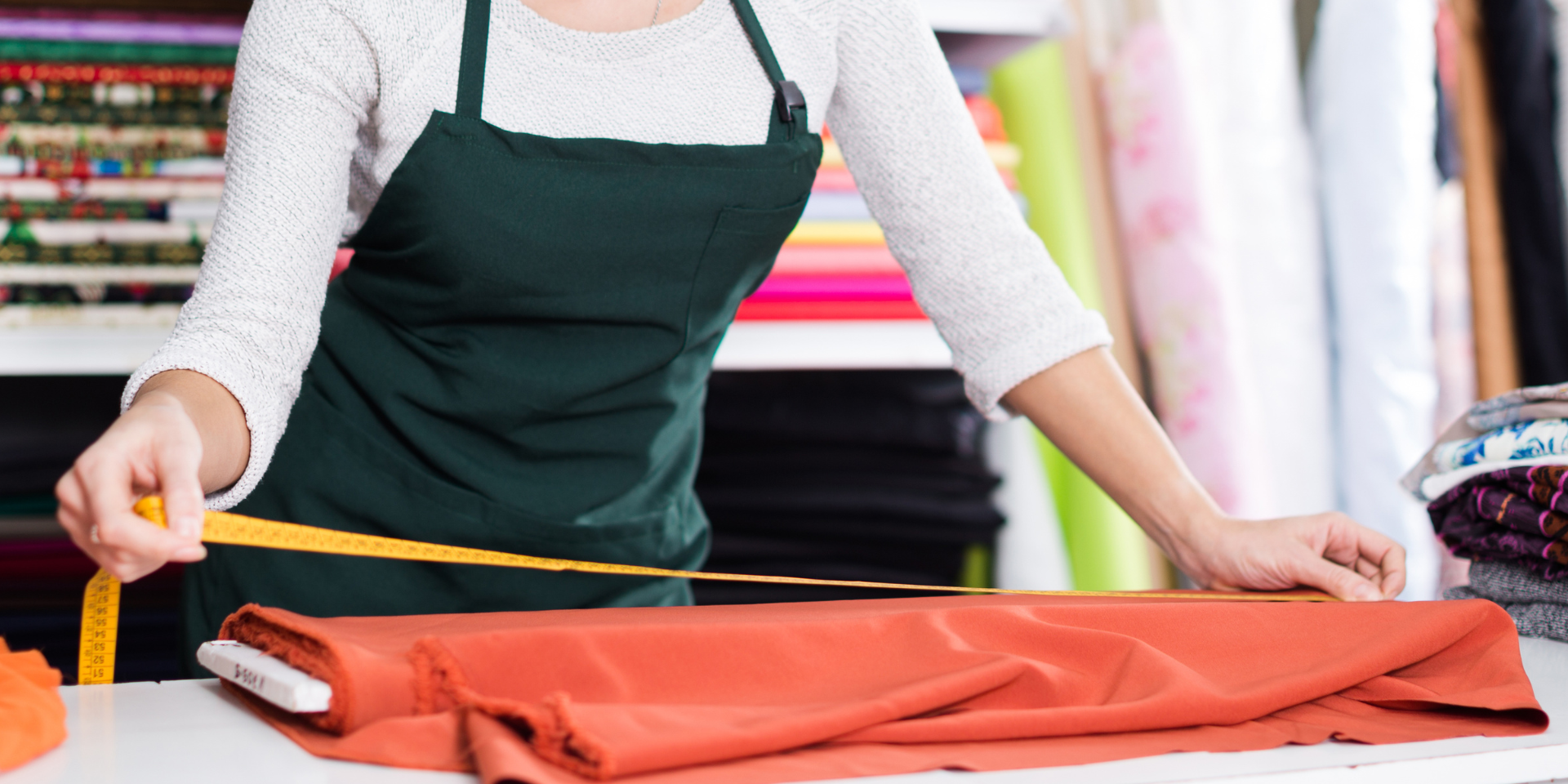 Entrepreneur measuring fabric in a workshop, representing the work of a textile startup developing innovative materials.