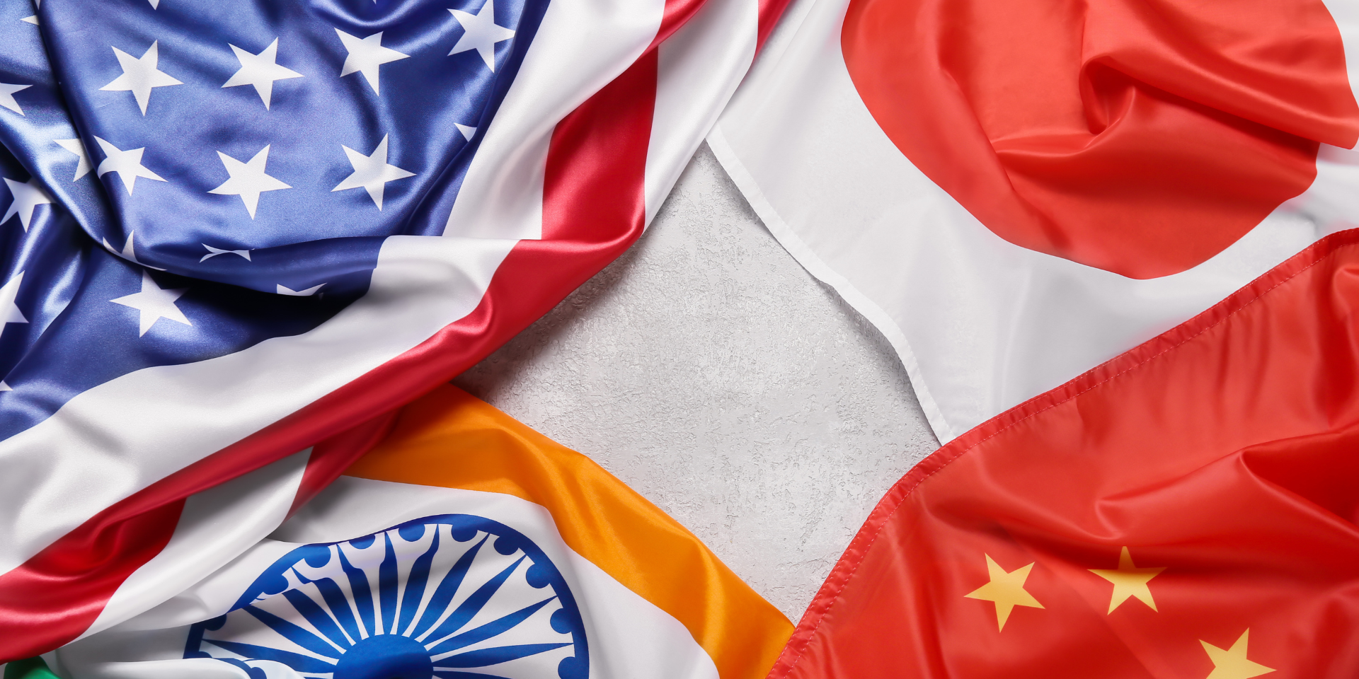 Four national flags arranged in a circular pattern with a blank space in the center.  